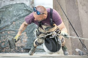 Working applying plaster treatment to the exterior of a house. Plastering Supplies In Portsmouth