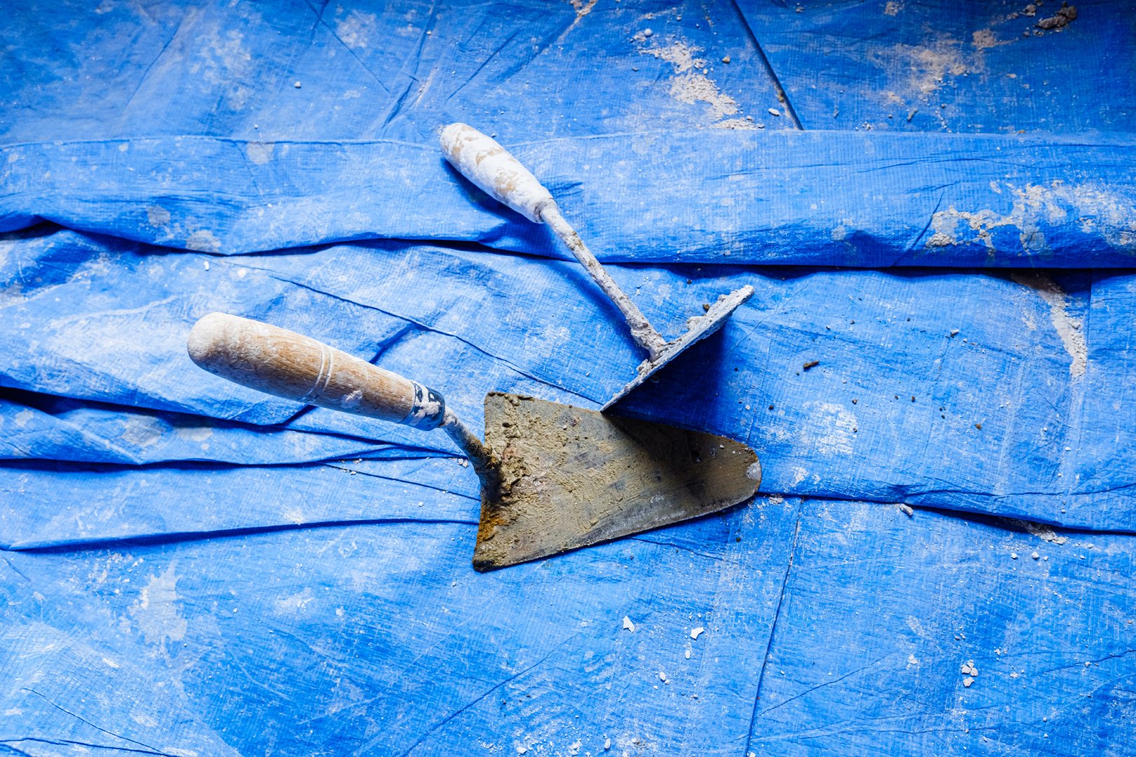 Tools of bricklayers on blue blanket during a cement work.